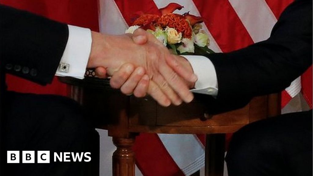 Macron Appears Reluctant During Prolonged Handshake with Trump, Sparks Debate